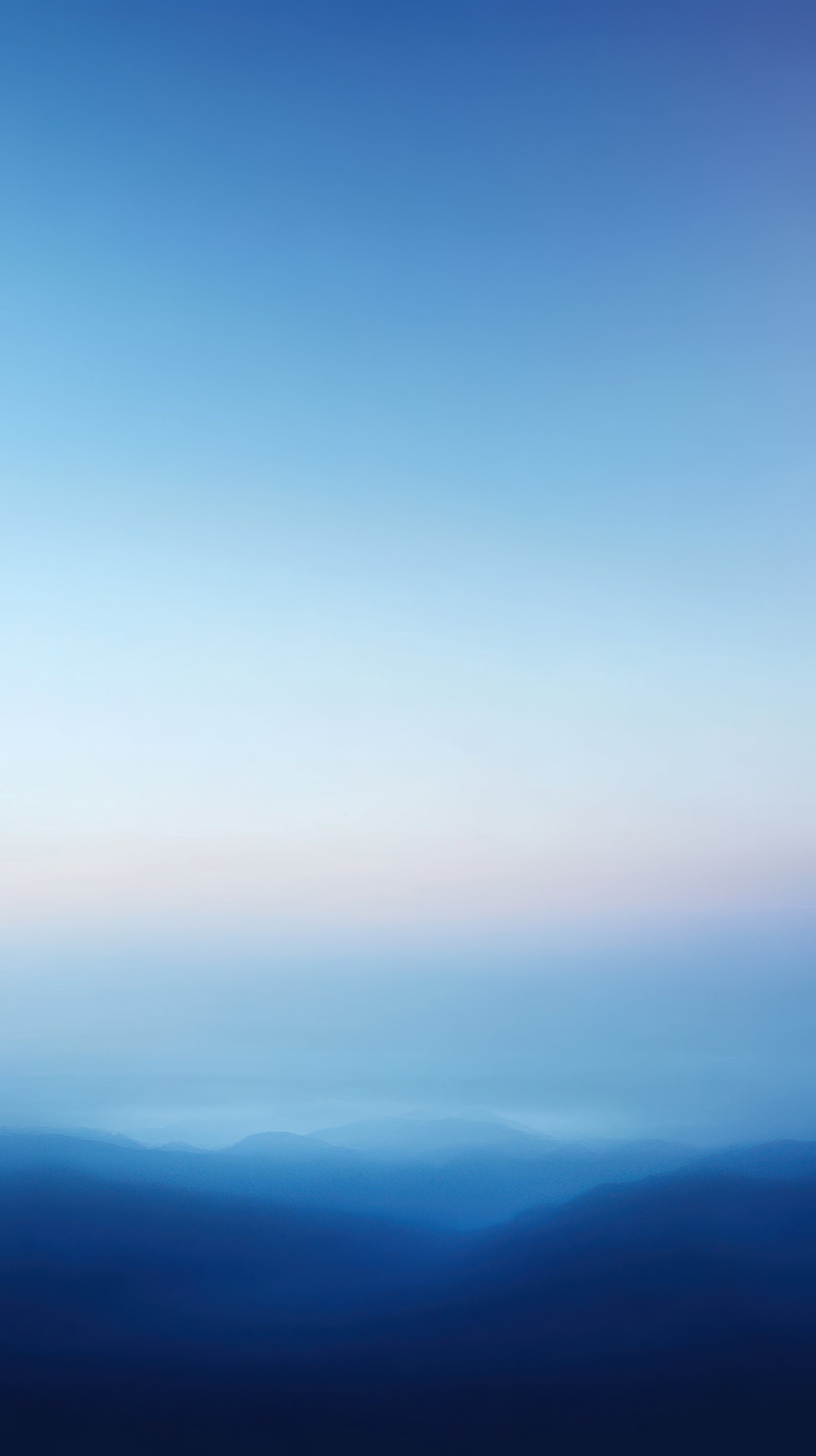 Serene twilight view of distant mountains under a pastel sky with gradual color transition in nature